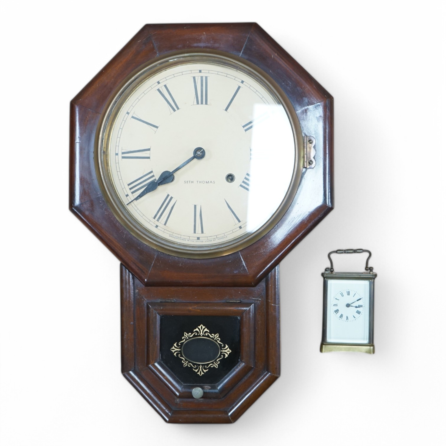 An American Seth Thomas mahogany wall clock and a French carriage timepiece, largest 55cm high. Condition - fair to good, untested